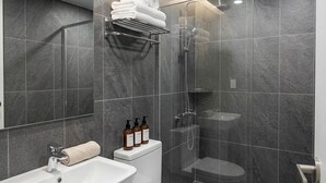 A modern bathroom with a glass-enclosed shower, a white sink, and a toilet. - HOTEL HIVE (Seoul)