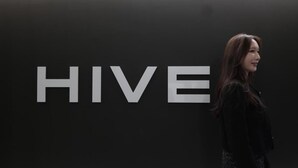 A person standing in front of a wall with the word 'HIVE' in large letters. - HOTEL HIVE (Seoul)