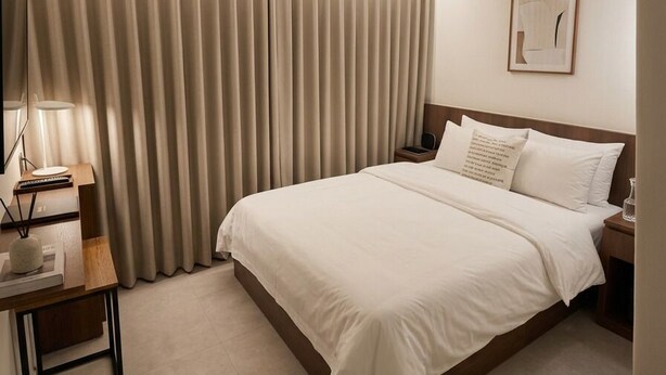 A hotel room with a bed, bedside table, lamp, and curtains. - HOTEL HIVE (Seoul)