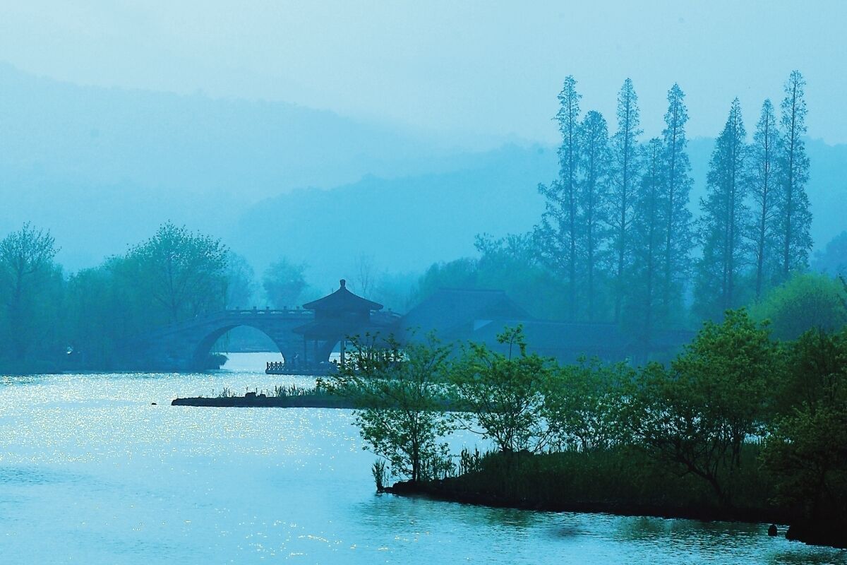 A serene riverside scene with a traditional bridge and pavilion.