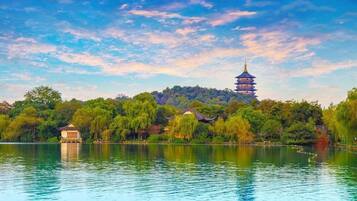 Una vista tranquila de un lago con una pagoda tradicional y un pabellón.