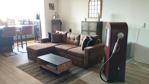 A living room with a sectional sofa, a coffee table, and a fireplace. There is a bicycle mounted on the wall and a cabinet with a globe on top. - House with panoramic ocean views and a pool (MARSEILLE 15EME)