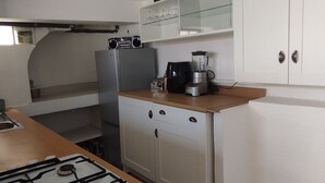 A kitchen with a gas stove, a refrigerator, a blender, and white cabinets. - House with panoramic ocean views and a pool (MARSEILLE 15EME)