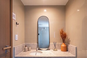 A bathroom with a large mirror, a sink, a toilet, and a shower. - Modern Apartment in a Cond. With gym Hgr0101 (Salvador)