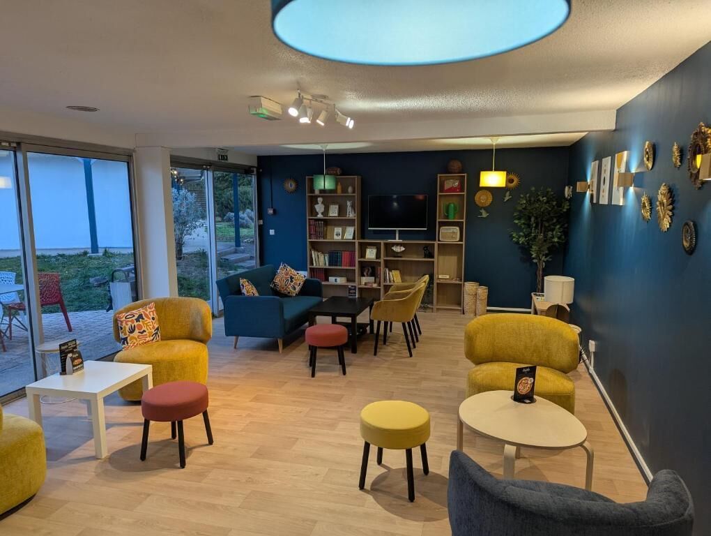 Una sala de estar moderna con un sofá, sillas, una mesa de centro y un televisor.