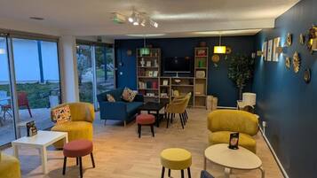 Una sala de estar moderna con un sofá, sillas, una mesa de centro y un televisor.