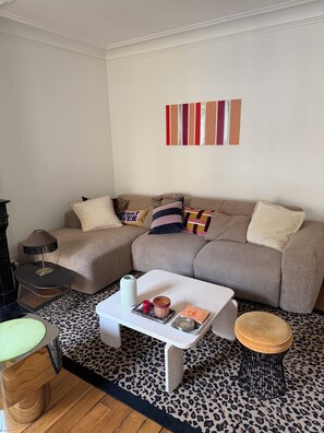 Ein Wohnzimmer mit einer Couch, einem Couchtisch und einem kleinen Hocker.