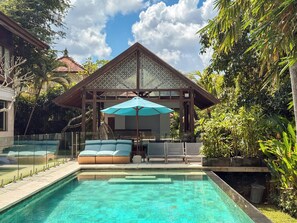 A pool area with a covered seating area, surrounded by lush greenery. - Villa Batu Sari - A Serene Luxury Retreat in the Heart of Canggu (Badung)