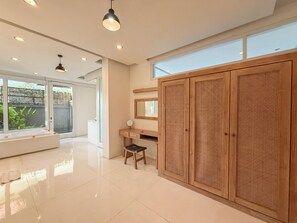 Ein modernes Badezimmer mit Badewanne, Waschtisch und großem Holzschrank.