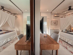 A modern bedroom with a bed, a TV, a wooden table, and a mirror. - Villa Batu Sari - A Serene Luxury Retreat in the Heart of Canggu (Badung)