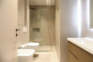 Ein modernes Badezimmer mit Toilette, Bidet und Waschbecken.