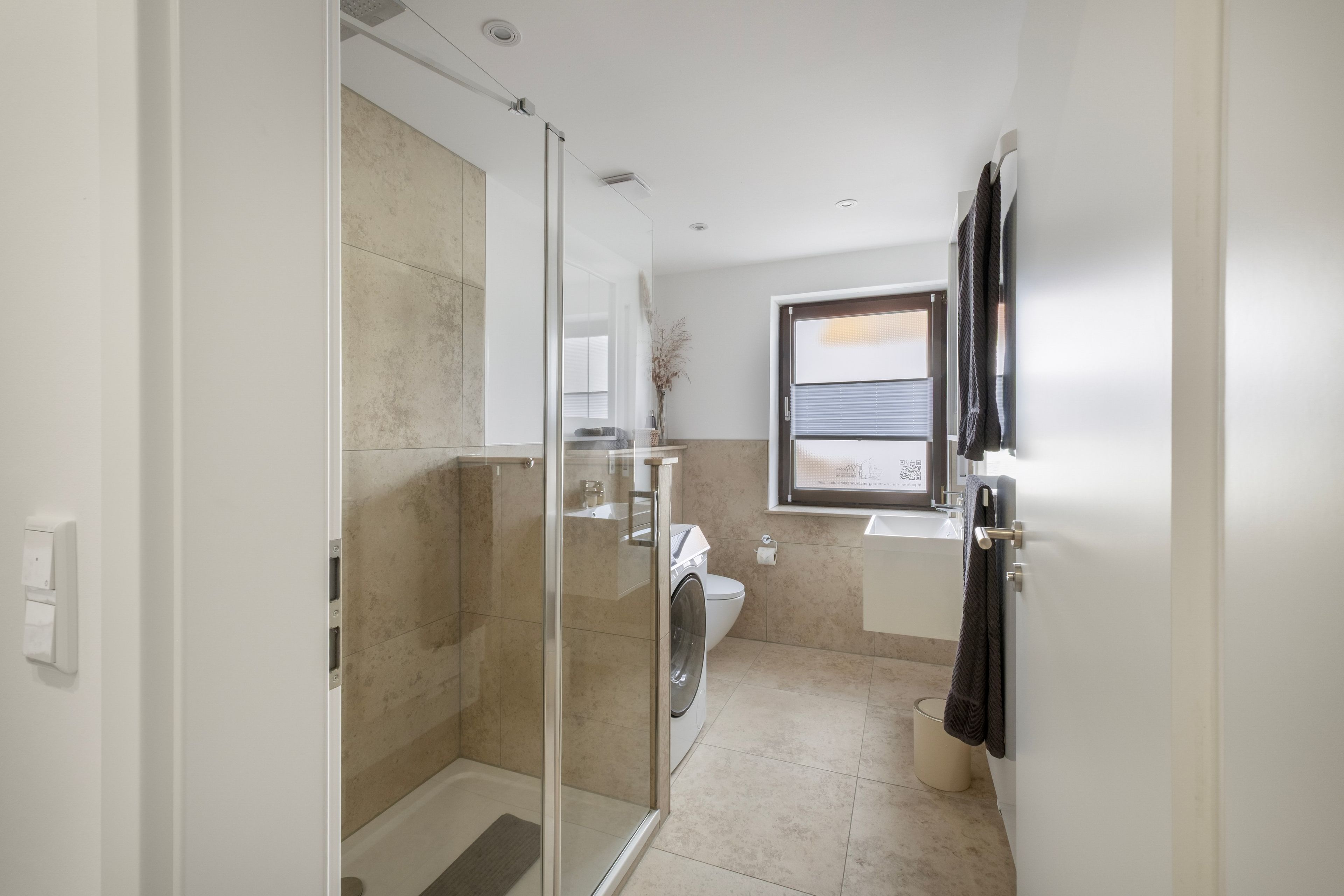 Une salle de bain moderne avec une douche à parois de verre, des toilettes et un lavabo.