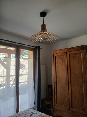 Ein Zimmer mit Holzschrank, Deckenventilator und einem fenster mit Vorhängen.