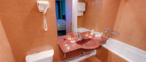 A bathroom with a toilet, sink, and bathtub.