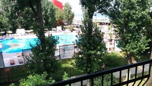 A pool area with a sign for 'maritimo' and a fenced garden with trees. - Hotel Palas (Constanța)