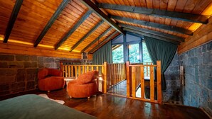 A wooden interior with a stone wall, a wooden ceiling, and a view through a window. - Dolana Wadi Taş Evleri (Ardeşen)