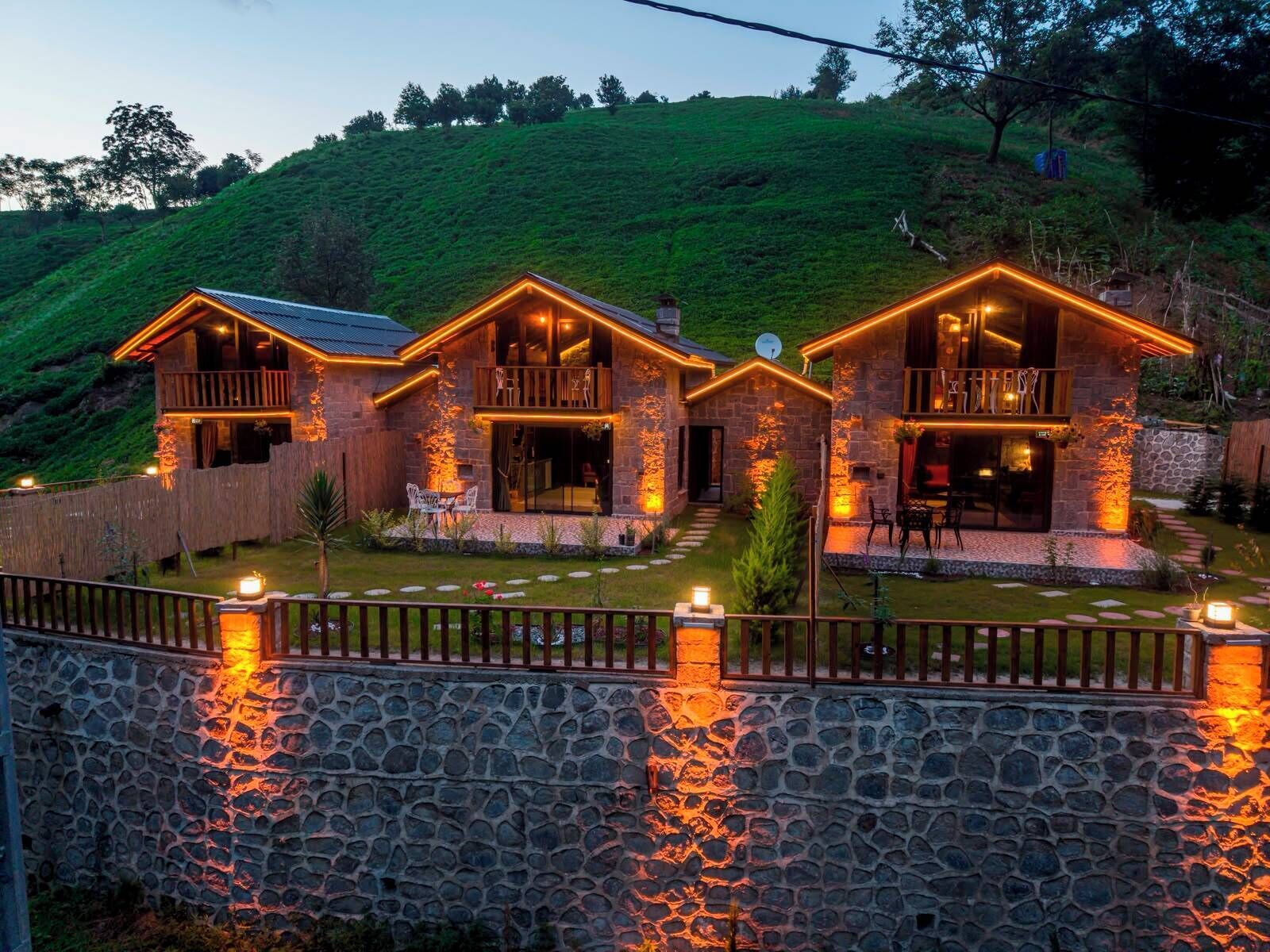 A stone house with a stone wall and a wooden fence.