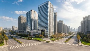 A modern high-rise building with a glass facade, surrounded by a well-maintained urban street with crosswalks and greenery. - Xian Fengdong Grand SkyLight Hotel (Xi'an)