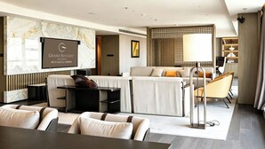 A modern hotel room with a marble wall, a flat-screen TV, a sofa set, a dining table, and a lamp. - Xian Fengdong Grand SkyLight Hotel (Xi'an)