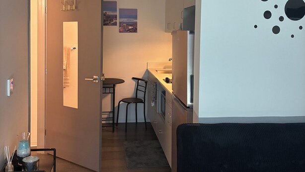 Kompakti oleskelutila, jossa on pieni keittiö, ruokailualue ja oleskelualue.