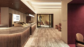 Un área de recepción de hotel con diseño moderno, que incluye un mostrador de recepción, un área de espera con asientos y un camino despejado hacia la entrada.