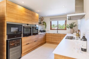 Eine moderne Küche mit Holzausstattung, Edelstahlgeräten und einer weißen Arbeitsplatte.