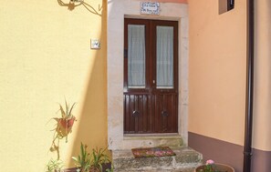 A two-door entrance with a welcome mat, potted plants, and a sign above the door. - 1 bedroom beautiful home in Palazzolo Acreide (Palazzolo Acreide)