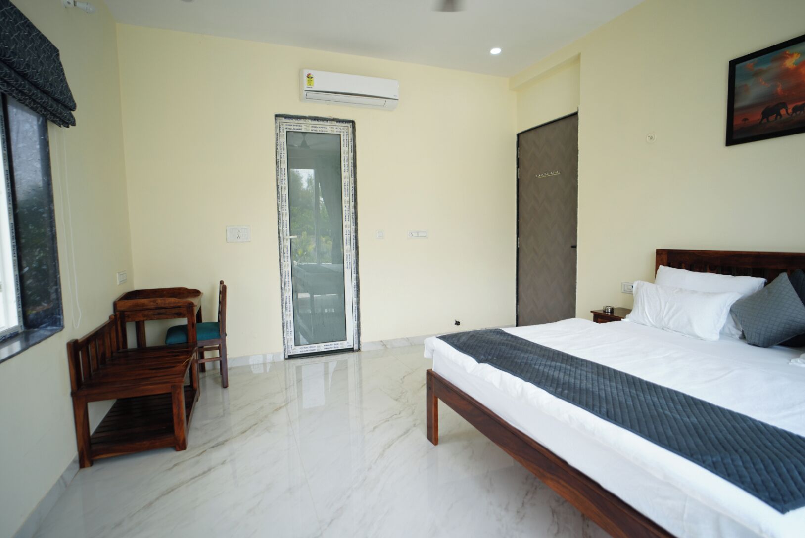 Une chambre d’hôtel équipée d’un lit, d’une chaise, d’un bureau, d’une porte et d’un appareil de climatisation.