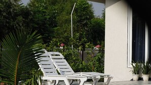 A pool area with lounge chairs and potted plants. - Luxury 3BHK Farmhouse Near Jaipur with Private Pool & Garden (jaipur)