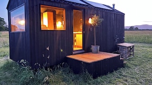 A small wooden cabin with a porch, a single door, and a window. - Literally do Nothing but Relax & Unwind (Worcester)