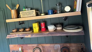 A kitchen with wooden shelves, a coffee maker, a kettle, and a sign for Spitalfields Old Market. - Literally do Nothing but Relax & Unwind (Worcester)