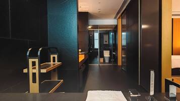 A modern bathroom with a bathtub, a towel, a mirror, and a sink.