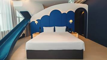 Una habitación de hotel moderna con una cama grande, una mesita de noche, un teléfono en la pared y un panel de control.
