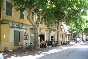 A street with outdoor seating at a cafe and a hotel bar. - Large holiday home with a swimming pool in Le Var (Collobrieres)