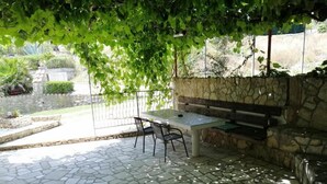 An outdoor patio with a stone floor, a table, chairs, and a bench. - Apartments Katarina -one Bedroom Apartment With Terrace (Vis)