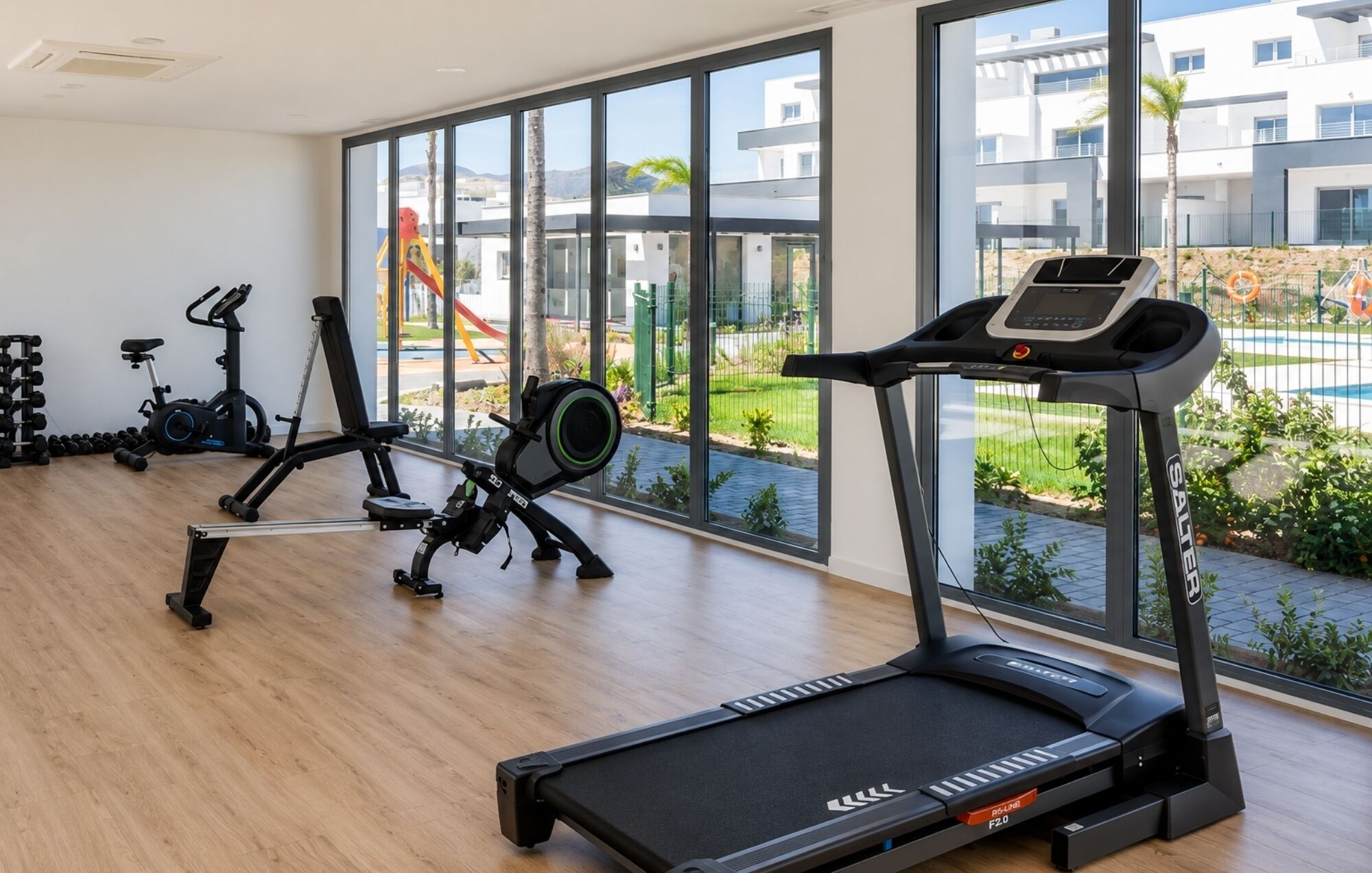 A gym with treadmills, weight machines, and dumbbells.