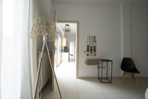 A room with a radiator, a lamp, a chair, and wall decorations.
