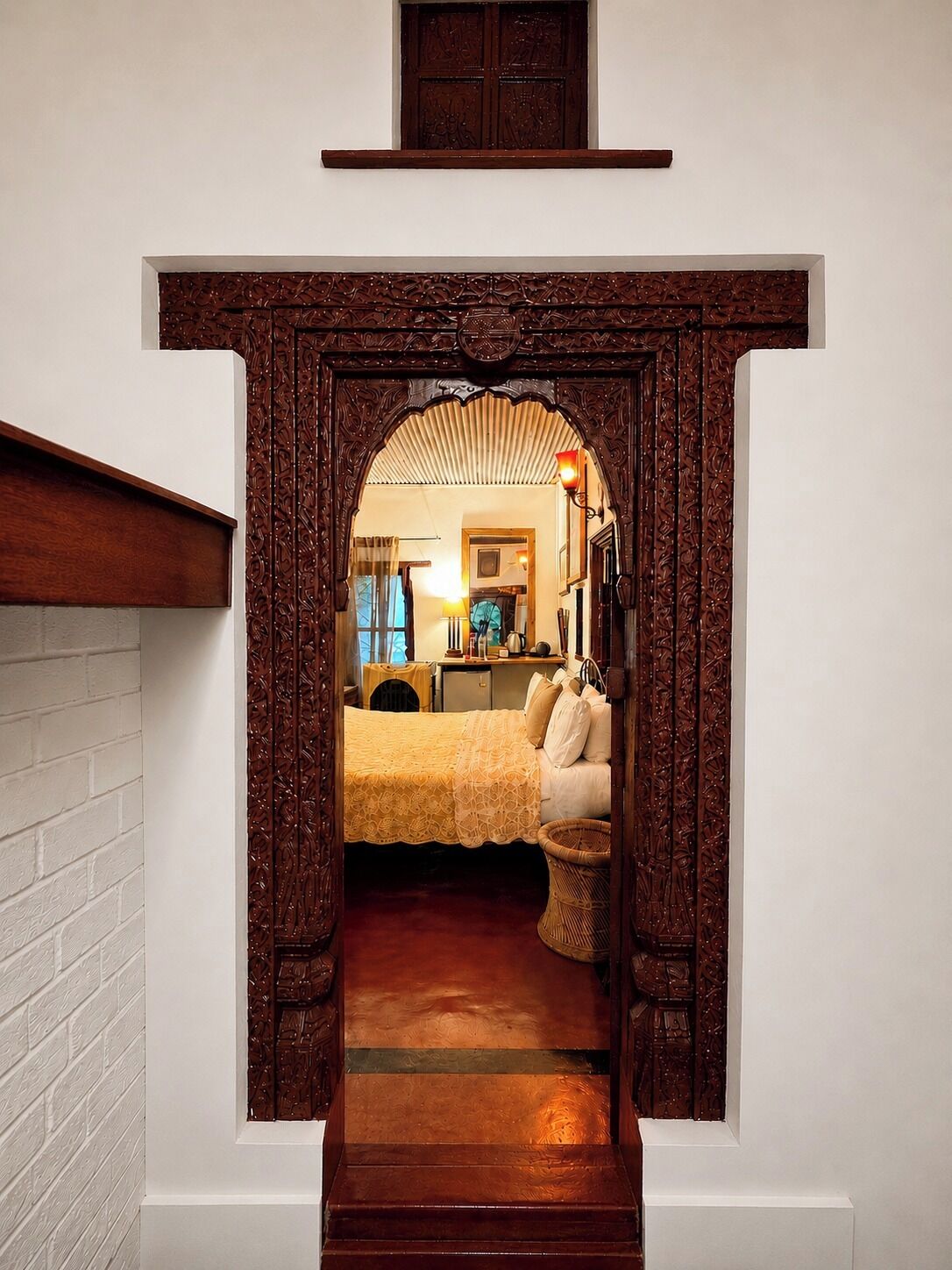 Un dormitorio con una cama, mesita de noche, lámpara y ventana.