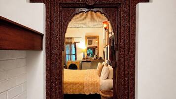 Un dormitorio con una cama, mesita de noche, lámpara y ventana.