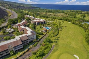 Vista aèria d'un complex turístic amb diversos edificis, un camp de golf i vista a l'oceà.