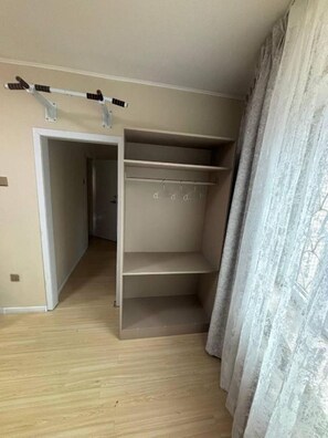A room with a built-in closet, wooden flooring, and a door leading to another room. - Superb 3-bedroom apartment in Ulaanbaatar for your stay (Ulaanbaatar)