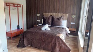 Un dormitorio con cama, armario de madera, sillón colgante y mesita de noche.