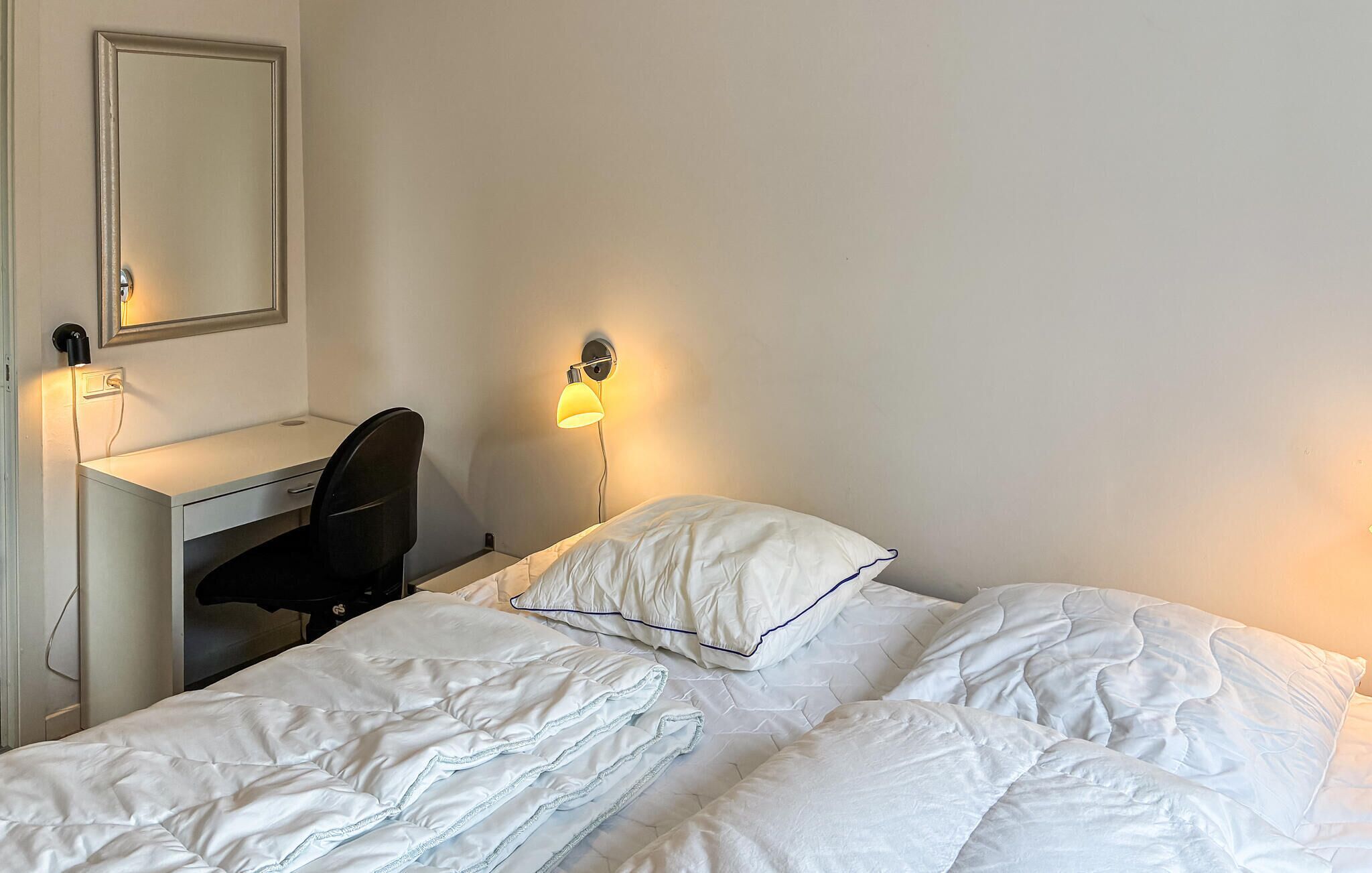 Une chambre à coucher avec un lit, un bureau et une chaise.