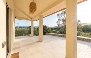 Un espace extérieur abrité offrant une vue sur un paysage montagneux.