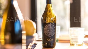 A bottle of wine on a table with a window in the background. - Villa Le Sfumature Mediterranee - Sardinia Unlimited (San Teodoro)