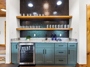 A kitchen with a dishwasher, a stainless steel oven, and a teal-colored cabinet with a wooden shelf above. - Sleeps 20 + Indoor Pool + Game Room Near Pigeon Forge | Spurling Retreat (Sevierville)