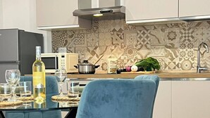 Een moderne keuken met een eettafel, stoelen en een hond die op de vloer ligt.