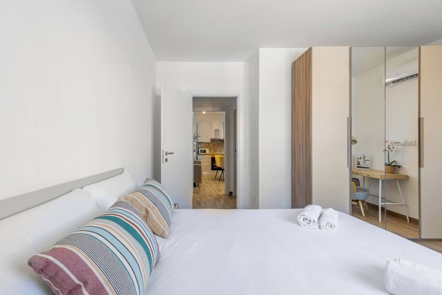 Een hotelkamer met een bed, een bureau en een spiegel.