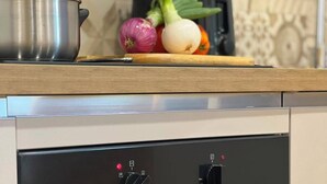 Een moderne keuken met een inbouwoven en een roestvrijstalen pan op het aanrecht.