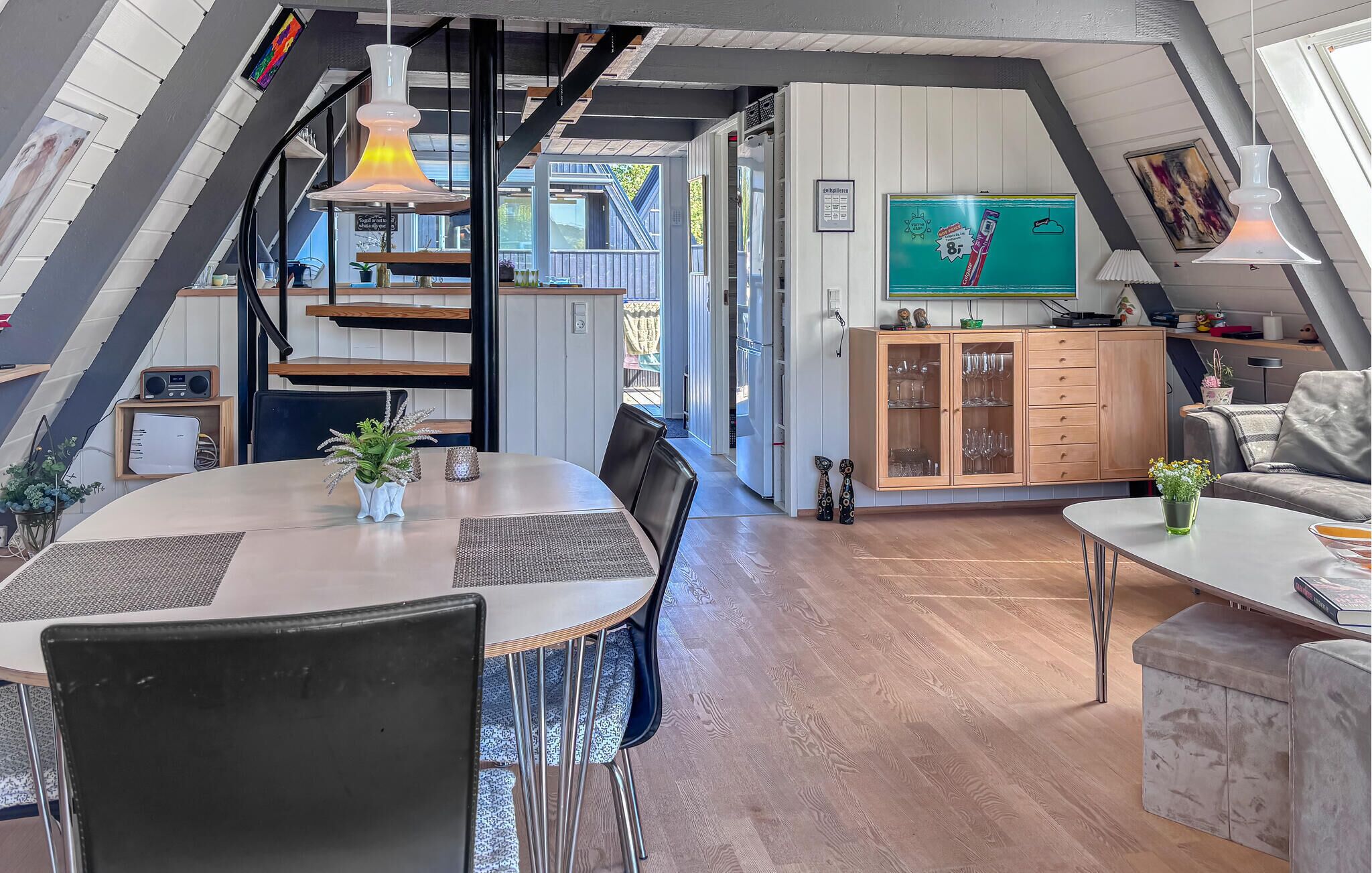 A modern loft-style living space with a dining area, kitchen, and a cozy seating area.